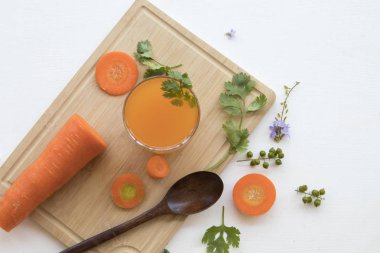 Bitkisel sağlıklı içecekler limon dilimi, Mor çiçek dekorasyonu düz ile havuç ve limon kokteyl su yatıyordu tarzı ahşap arka plan beyaz