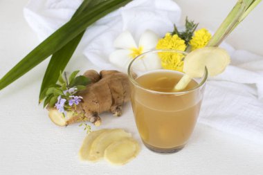 Bitkisel sağlıklı içecekler zencefil şurubu kokteyl su sağlık ile limon, limon dilimi, pandan yaprak ve çiçek dekorasyon düz stil arka plan beyaz tahta üzerinde yatıyordu