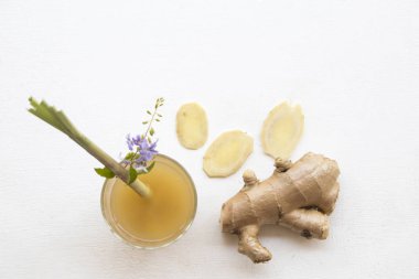 Bitkisel sağlıklı içecekler Zencefil limon otu ve çiçek dekorasyonu düz ile sağlık şurubu kokteyl su yatıyordu tarzı ahşap arka plan beyaz