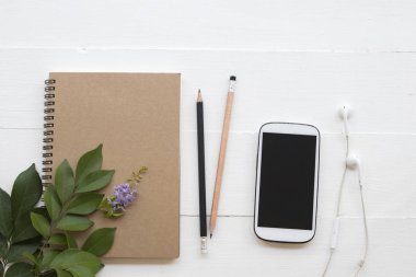 cep telefonu, dizüstü bilgisayar, öğrenci yazma Not kalem çalışma dekorasyon düz için stil arka plan beyaz tahta üzerinde yatıyordu