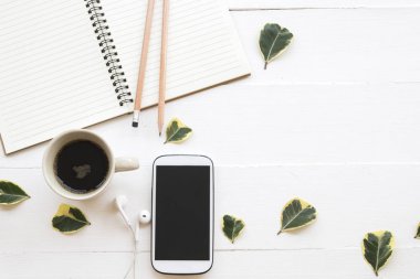 defter planlayıcısı, cep telefonu iş çalışma için sıcak kahve ve yaprak dekorasyon ile düz stil beyaz arka plan üzerinde yatıyordu. 