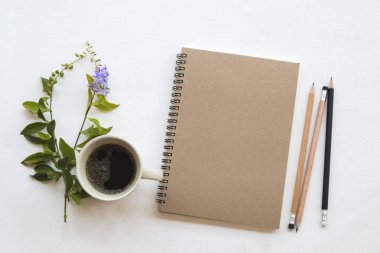 iş iş için defter planlayıcısı sıcak kahve ve yaprak dekorasyon ile düz stil beyaz arka plan üzerinde yatıyordu. 