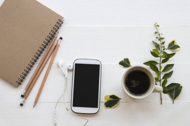 defter planlayıcısı, cep telefonu iş çalışma için sıcak kahve ve yaprak dekorasyon ile düz stil beyaz arka plan üzerinde yatıyordu. 