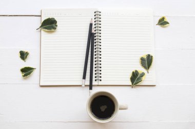 iş iş için defter planlayıcısı sıcak kahve ve yaprak dekorasyon ile düz stil beyaz arka plan üzerinde yatıyordu. 