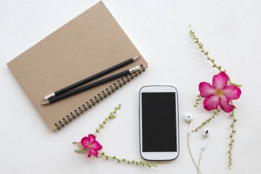 defter planlayıcısı ve cep telefonu iş için iş ile pembe çiçek dekorasyon düz beyaz arka plan üzerinde yatıyordu stili 