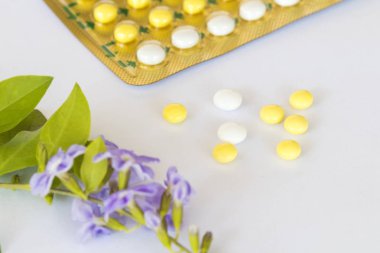 Doğum kontrol hapları Doğum kontrol hapları kadın için mor çiçek dekorasyon düz bebeğe sahip istemiyorum stil beyaz arka plan üzerinde yatıyordu 