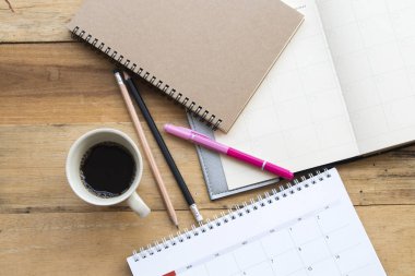 defter planlayıcısı, takvim iş iş için sıcak kahve dekorasyon düz stil ahşap zemin üzerinde yatıyordu.