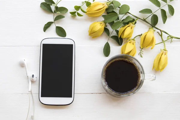 Mobilní Telefon Horké Černé Kávy Žlutými Květy Ylang Ylang Rostlinstvo — Stock fotografie