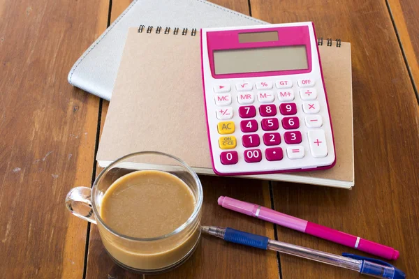 notebook planner ,calculator for business work with hot coffee at office desk
