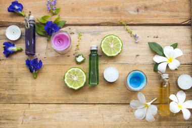doğal bitkisel yağlar çiçek Frangipani ekstresi, mavi çiçek kelebek bezelye ve narenciye Limes yerel Asya aranjman düz arka planda ahşap yatıyordu tarzı 