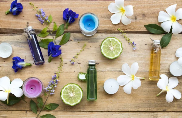 doğal bitkisel yağlar çiçek Frangipani ekstresi, mavi çiçek kelebek bezelye ve narenciye Limes yerel Asya aranjman düz arka planda ahşap yatıyordu tarzı 