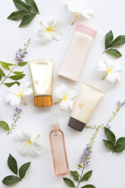 doğal kozmetik güneş kremi spf50, su sprey Sağlık Cilt yüz ve vücut losyonu yaşam tarzı kadın sakin yaz çiçek frangipani düzenleme düz ile stil beyaz arka plan üzerinde yatıyordu 