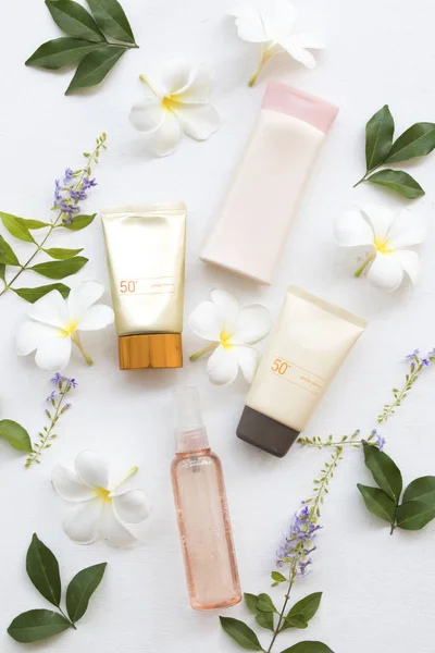doğal kozmetik güneş kremi spf50, su sprey Sağlık Cilt yüz ve vücut losyonu yaşam tarzı kadın sakin yaz çiçek frangipani düzenleme düz ile stil beyaz arka plan üzerinde yatıyordu 