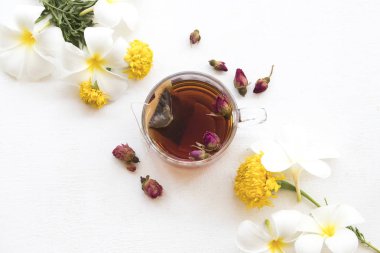 Bitkisel sağlıklı içecekler sıcak gül çay kokteyl su çiçekler frangipani, kadife çiçeği, kurutulmuş gül aranjman arka plan beyaz tahta üzerinde stil yat