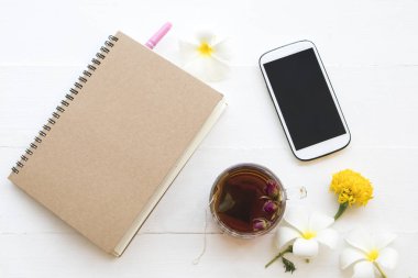 dizüstü bilgisayar, cep telefonu için iş iş ve bitkisel sağlıklı içecekler sıcak gül çay kokteyl su çiçekler frangipani, kadife çiçeği, kurutulmuş gül aranjman arka plan beyaz tahta üzerinde stil yat