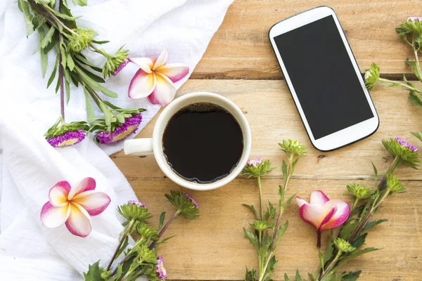 cep telefonu ve mor çiçekler ile sıcak kahve espresso, frangipani düzenleme düz yatıyordu ahşap arka plan stili