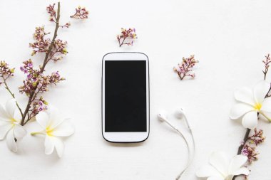 hareket eden telefon ile kulaklık ve çiçek sepeti düz beyaz arka plan üzerinde yatıyordu stil 