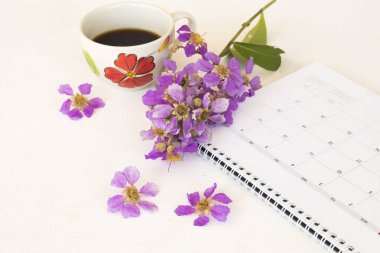 Takvim planı, sıcak kahve ve mor çiçekler bahar sezonu düzenleme düz arka planda beyaz yatıyordu tarzı 
