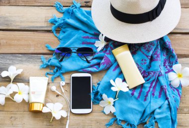 sağlık için güneş kremi spf50 vücut losyonu ile cilt yüzünü korumak, şapka, cep telefonu, güneş gözlüğü ve yaşam tarzı kadın eşarp rahatlayın yaz aranjmanı arka plan ahşap düz yatıyordu tarzı