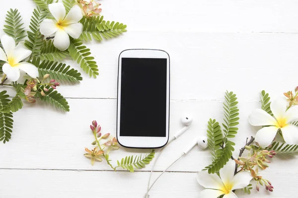 cep telefonu, kulaklık ve çiçek düzenleme düz arka plan beyaz stil yatıyordu 