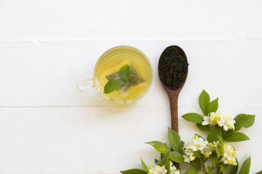 bitkisel sağlıklı içecekler ahşap kaşık ve çiçek yasemin püresi yaprak çay ile sıcak yeşil çay rahatyaşam tarzı düzenleme düz arka plan beyaz tarzı yatıyordu 