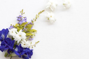 mavi çiçek kelebek bezelye, beyaz çiçek yasemin ve mor çiçek asya düzenleme düz döşeme tarzı arka plan beyaz 