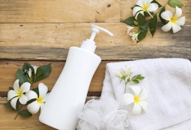 terry bez ile vücut cilt için doğal bitkisel sıvı sabun sağlık bakım, arka plan ahşap üzerinde çiçek frangipani düzenleme düz yatıyordu tarzı
