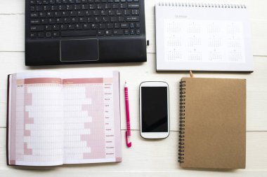 defter planlayıcısı, takvim, bilgisayar ve cep telefonu iş düzeni için düz arka plan beyaz stil yatıyordu 