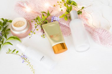 güneş kremi spf50 ,toners serum terapi kozmetik , yaşam tarzı kadın düzenleme düz döşeme tarzı örgü yün ile cilt yüzü için göz kremi sağlık arka plan beyaz stil 