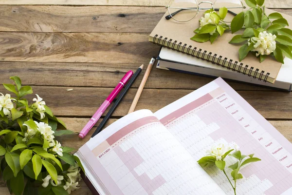 notebook project year planner of business work with flowers jasmine arrangement flat lay style on background wooden