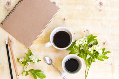 iş için dizüstü planlayıcısı ve sıcak kahve espresso ikiz fincan yaşam tarzı düzenleme düz arka plan ahşap tarzı yatıyordu