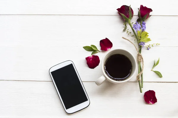 cep telefonu, sıcak kahve espresso ve kırmızı gül düzenleme düz arka plan beyaz ahşap tarzı yatıyordu