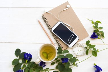 dizüstü planlayıcısı, iş için cep telefonu, bitkisel sağlıklı içecek ve mavi çiçekler kelebek bezelye düzenleme arka plan beyaz ahşap düz yatıyordu tarzı