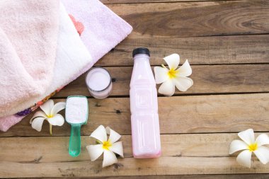 Tıbbi sıvı çözeltisi ile toz deterjan temizlik sağlık giysileri ve beyaz çiçek Frangipani aranjman ahşap arka planda düz yatıyordu tarzı