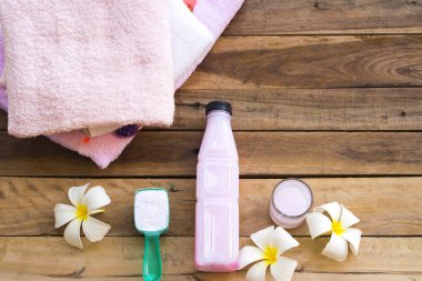 Tıbbi sıvı çözeltisi ile toz deterjan temizlik sağlık giysileri ve beyaz çiçek Frangipani aranjman ahşap arka planda düz yatıyordu tarzı