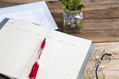 ahşap arka plan üzerinde iş iş aranjman düz yatmak için Takvim ile Notebook planlayıcısı