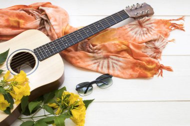 gitar, güneş gözlüğü ve yaşam tarzı kadın turuncu bez arka plan beyaz ahşap üzerinde sarı çiçekler düzenleme düz yatıyordu tarzı ile yaz dinlenmek