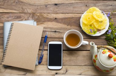 notebook planlayıcısı, bitkisel sağlıklı içecekler sıcak çay ve yaşam tarzı tatlı kurutma ananas ile iş için cep telefonu ofis düzenleme düz döşeme tarzı arka plan ahşap dinlenmek