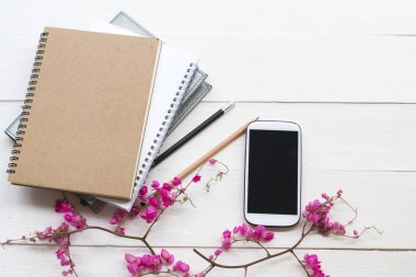 iş için cep telefonu ile dizüstü planlayıcısı ve renkli pembe çiçekler düzenleme arka plan beyaz düz yatıyordu tarzı 