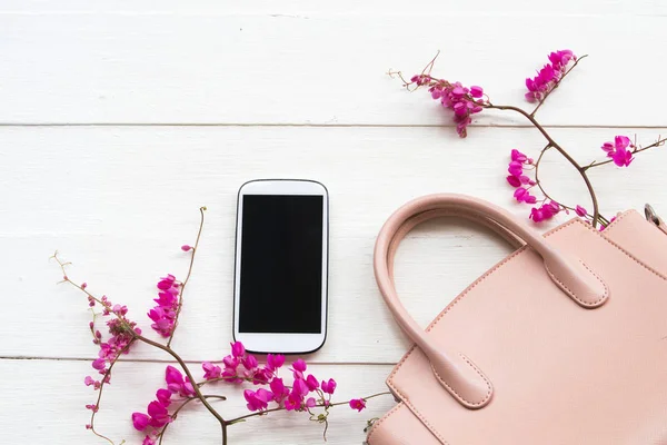 cep telefonu ile yaşam tarzı moda kadın pembe el çantası koleksiyonu, pembe küçük çiçekler düzenleme arka plan beyaz ahşap stil yatıyordu
