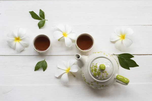 herbal healthy drinks tea for health care sore throat with teapot ,flowers frangipani of lifestyle relax arrangement flat lay style on background white