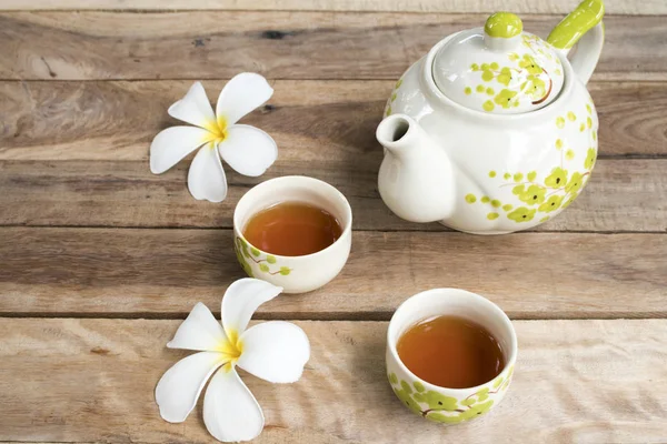 herbal healthy drinks tea for health care sore throat with teapot ,flowers frangipani of lifestyle relax  arrangement flat lay style on background  wooden
