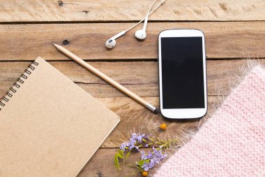 dizüstü planlayıcısı, cep telefonu ve kulaklık iş için pembe örgü yün eşarp ile yaşam tarzı kadın düzenleme düz ofis masasında arka plan ahşap tarzı yatıyordu