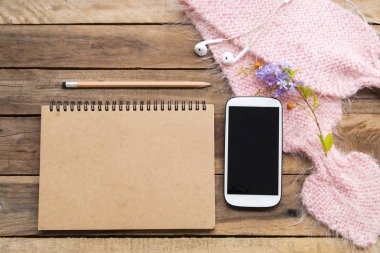 dizüstü planlayıcısı, cep telefonu ve kulaklık iş için pembe örgü yün eşarp ile yaşam tarzı kadın düzenleme düz ofis masasında arka plan ahşap tarzı yatıyordu