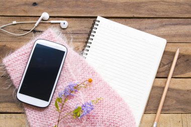 dizüstü planlayıcısı, cep telefonu ve kulaklık iş için pembe örgü yün eşarp ile yaşam tarzı kadın düzenleme düz ofis masasında arka plan ahşap tarzı yatıyordu