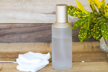 Terapi, pamuk doğal kozmetik içeren ilk serum tonerleri, cilt için bitkisel sağlık hizmetleri sunar. Kadın düzeninin güzelliği, arka plandaki tahta üzerinde düz bir şekilde yatar.