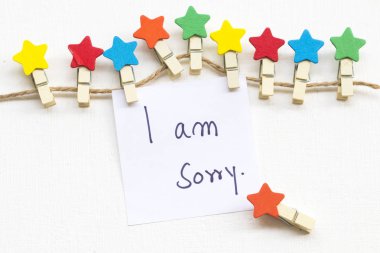 renkli ahşap yıldız klipleri düzenleme düz arka plan beyaz kartpostal tarzı yatıyordu ile üzgünüm mesaj kartı el yazısı 