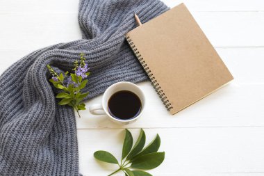 İş için not defteri planlayıcısı sıcak kahve espresso, mor çiçekler ve örgü yün ören kadın kış mevsimi düzenleme düz arka plan beyaz üzerine yatıyordu 