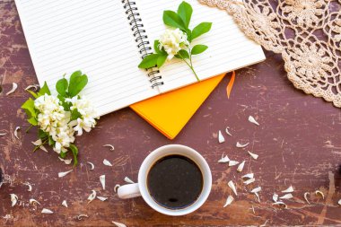 notebook planner for business work with hot coffee, white flowers jasmine, knitting yarn of lifestyle woman relax in summer  arrangement flat lay style on background wooden
