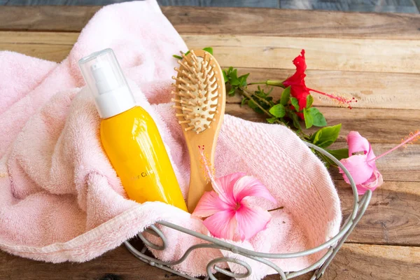 hair care serum for damaged hairs with comb health care beauty head and hairs with terry cloth in basket of lifestyle woman arrangement flat lay style on background wooden